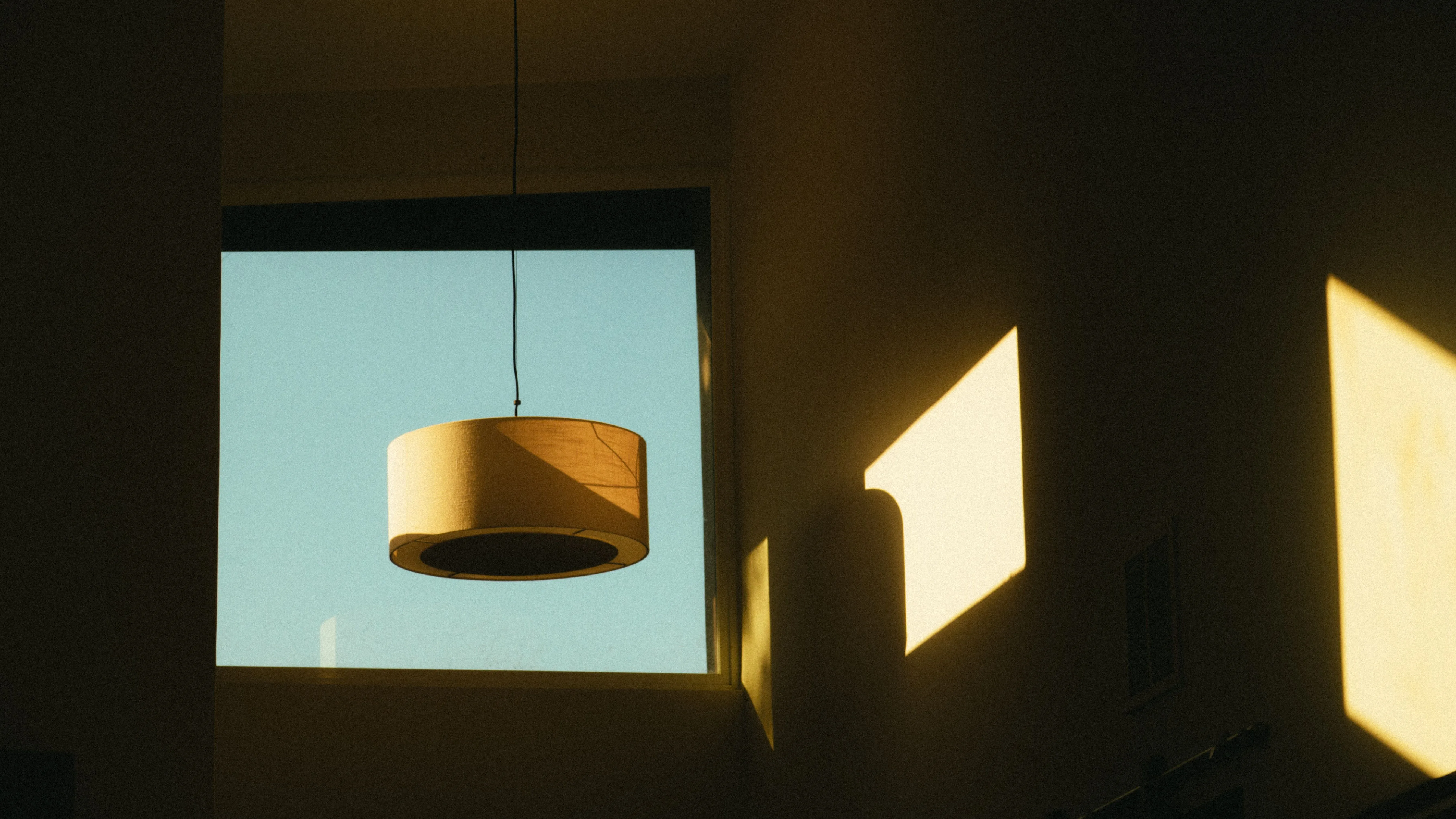 Lampa przy oknie i geometryczne światło na ścianie